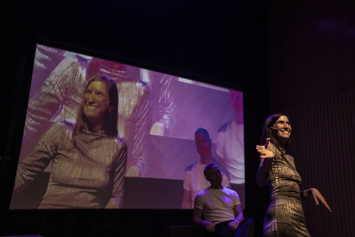 Sol Titiunik en escena con su imagen procesada por IA proyectada detrás